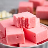 stacked pink fudge in a white dish.