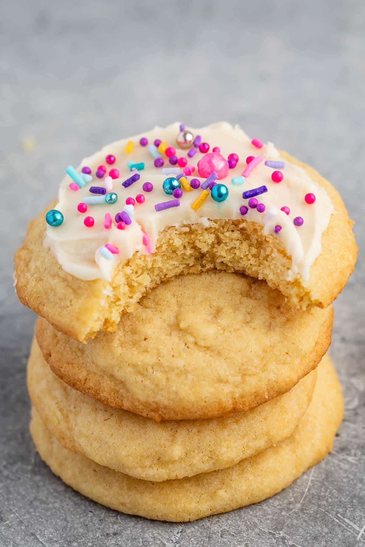 sugar cookie with white frosting and pink and blue sprinkles.