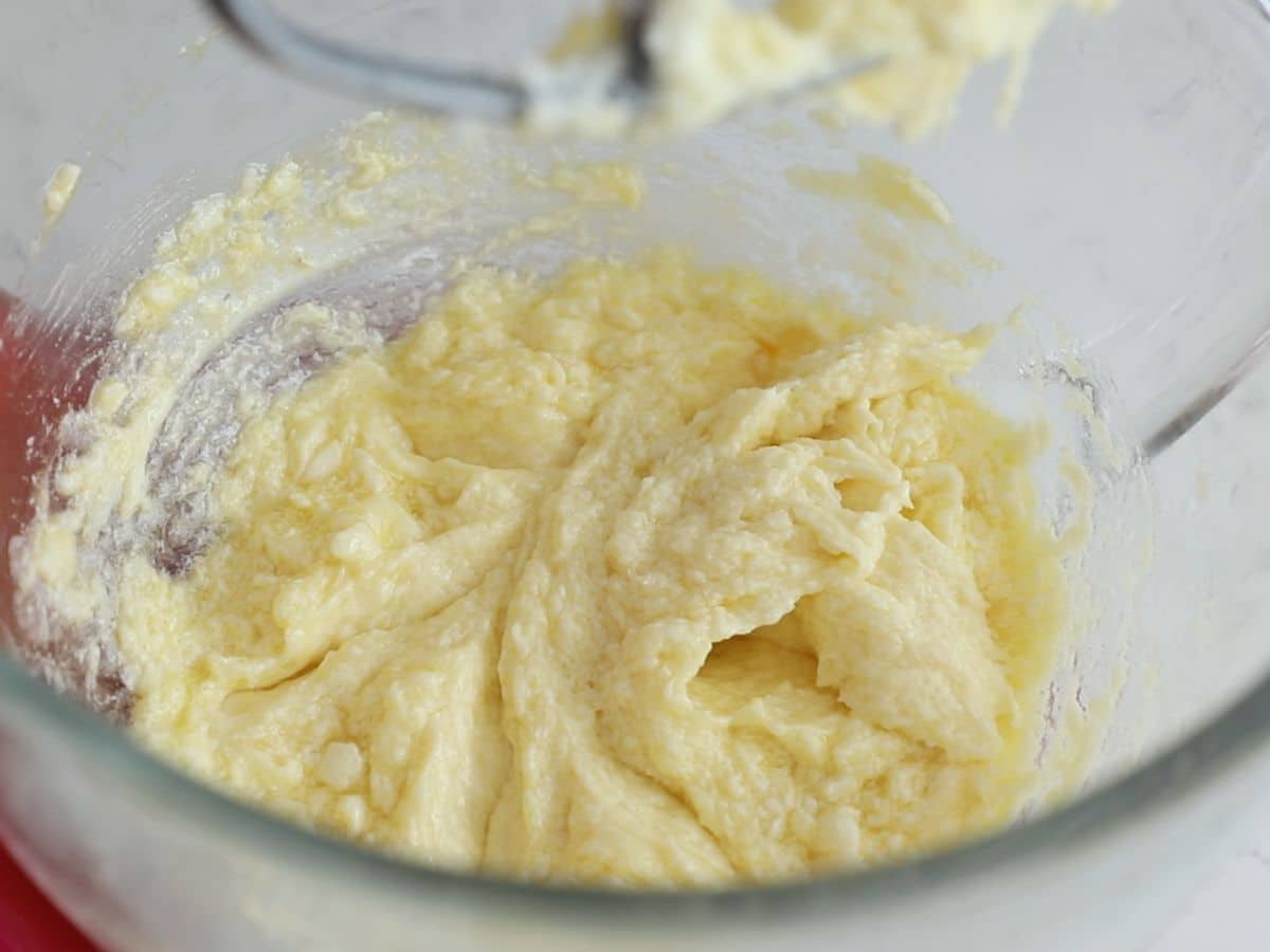 butter and sugar mixture in glass bowl of stand mixer.