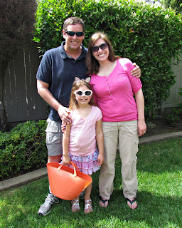 Family with husband wife and daughter on lawn, daughter holding easter basket