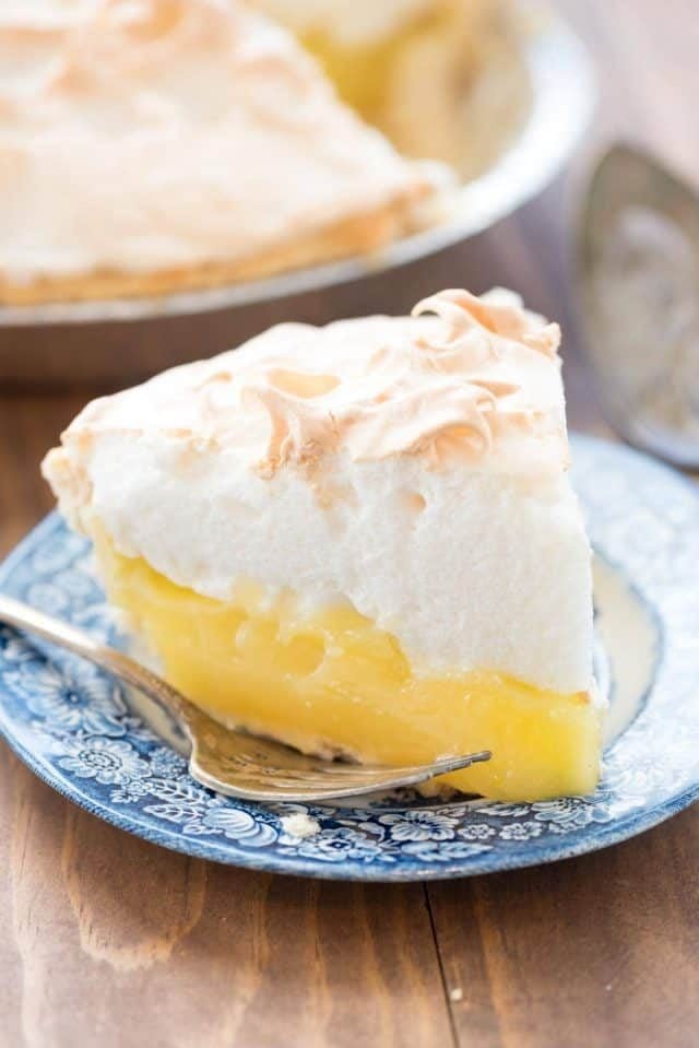 Lemon Meringue pie on a blue and white plate with a fork