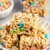 stacked Rice Krispie treats made from lucky charms on a white plate.